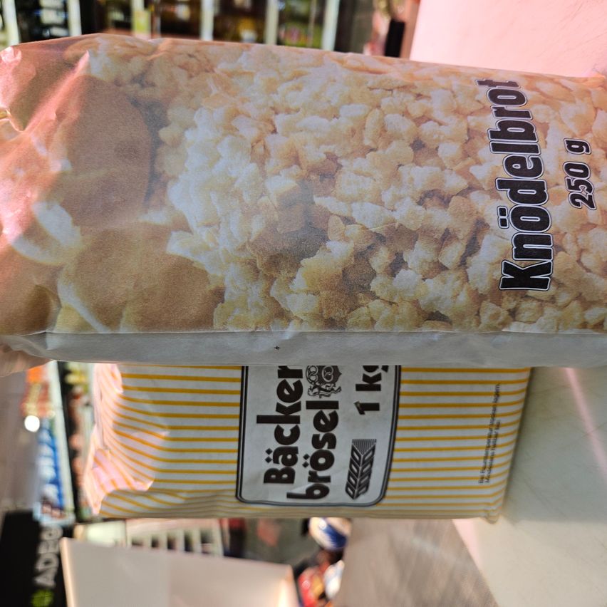 A bag of 'Knodelbrod' is shown, weighing 250 grams. The bag is yellow and white striped. The bottom of the bag has the label 'Backer brosel 1kg'.
