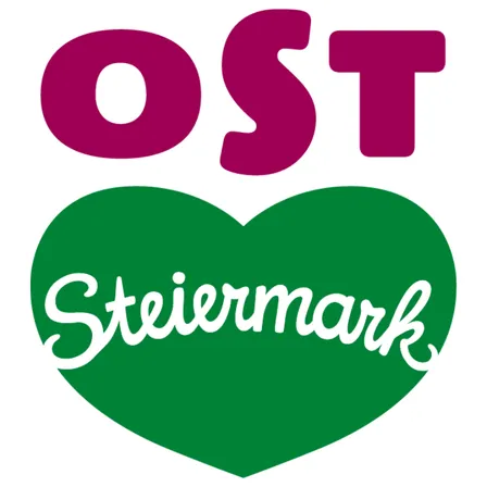 Ein herzförmiges Logo mit dem Wort 'OST' in fetten lila Buchstaben oben und 'Steiermark' in weißer Kursivschrift darunter.