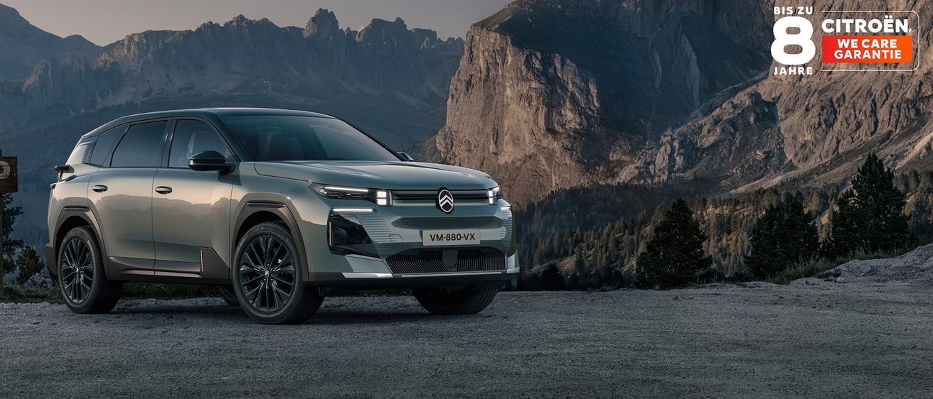 Ein grauer Citroen SUV steht auf einem Kiesweg mit einer Bergkette im Hintergrund. Der SUV hat ein modernes Design mit LED-Scheinwerfern.
