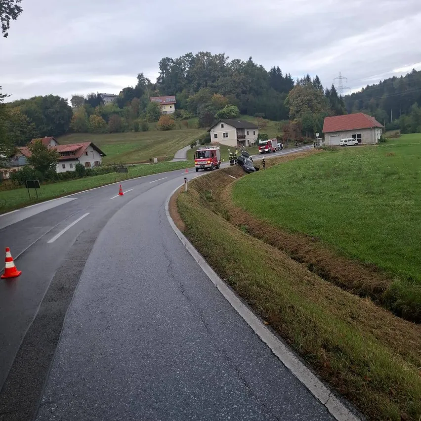 Eine Straße mit einem Unfallort, Rettungsfahrzeugen und Verkehrskegeln.