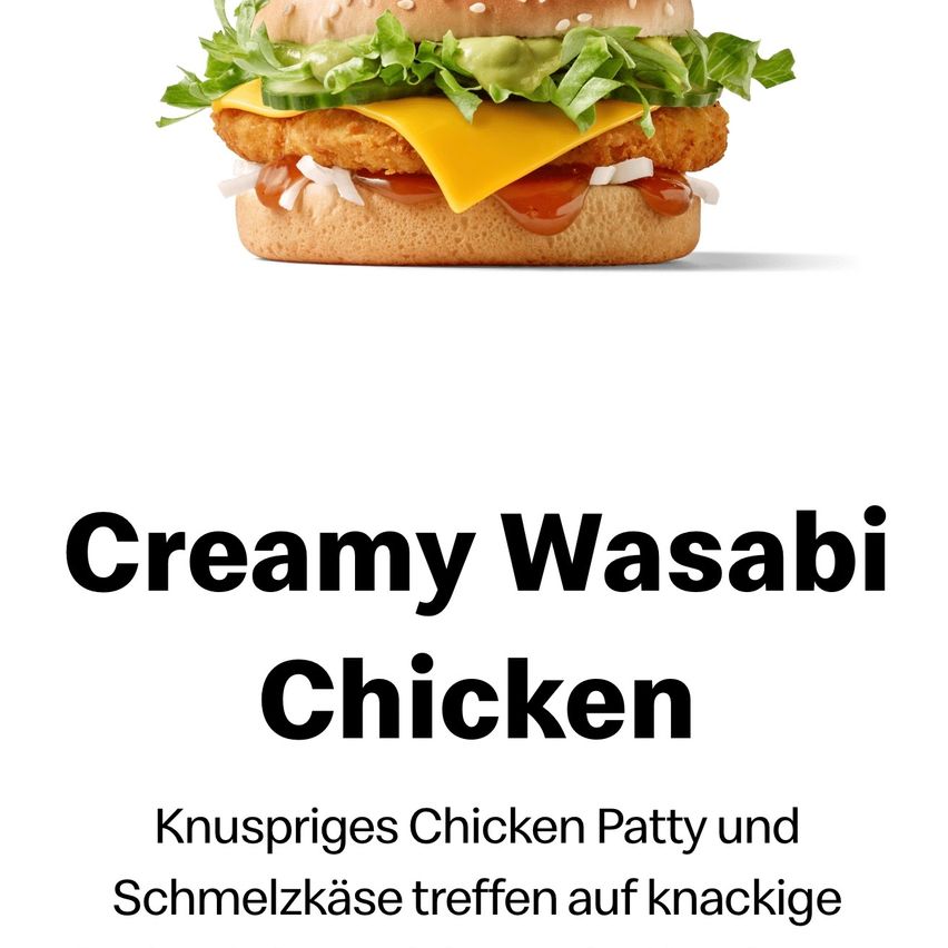 Das Creamy Wasabi Chicken besteht aus einem knusprigen Hähnchen-Patty, geschmolzenem Käse und einer cremigen Wasabi-Sauce. Obenauf Salat, Gurke und Zwiebel, serviert auf einem Brötchen.