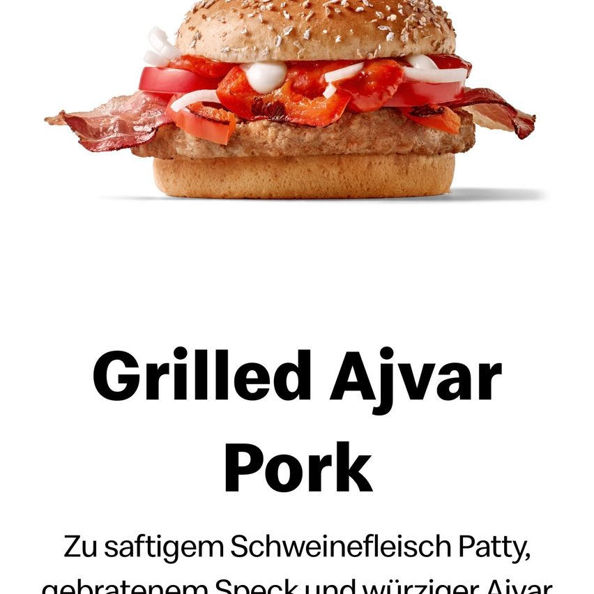 Ein Bild eines gegrillten Ajvar-Schweine-Burgers mit Speck, Tomaten, Zwiebeln und einer Patty. Darunter steht gegrillter Ajvar-Schweine-Burger mit einer Beschreibung in Deutsch.