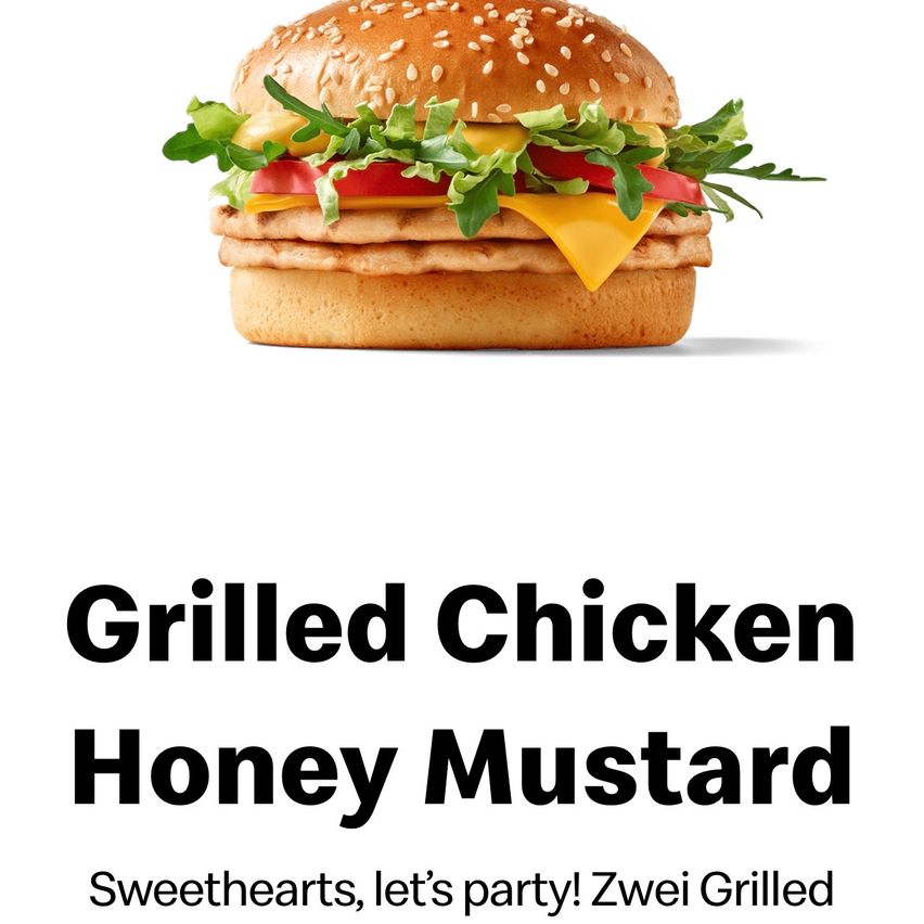 A close-up of a Grilled Chicken Honey Mustard burger with sesame seed buns, lettuce, tomato, and cheese. The burger is on a white background with bold text below.