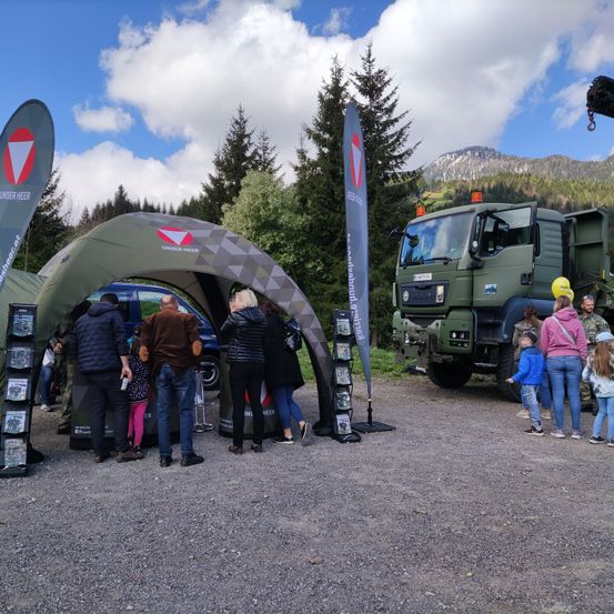 Bild enthält, Shoe, Person, Hat, Backpack, Helmet, Gun, Handbag, Truck, Fir, Outdoors
