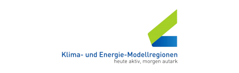 Schwarzer Hintergrund mit einem Logo, das 'Klima-und-Energie-Modellregionen' in weißer und blauer Schrift zeigt. Unter dem Logo steht in kleinerer Schrift 'heute aktiv, morgen gestalter'.