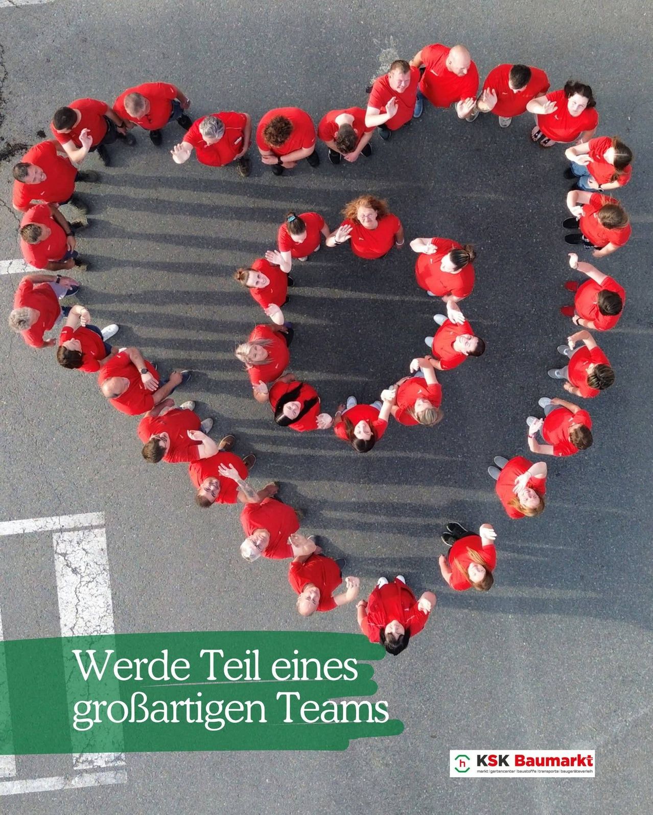 Eine Luftaufnahme einer Gruppe von Menschen in roten Shirts, die auf der Straße ein Herz formen. Der Text darunter lautet: 'Werde Teil eines großartigen Teams.'