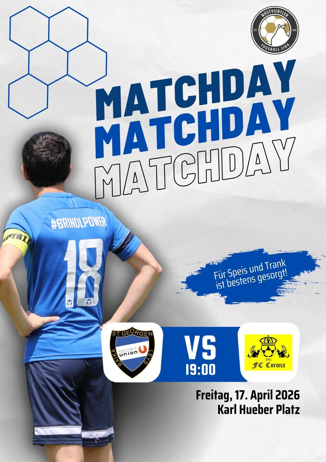 Ein Mann in einem blauen Trikot steht gegen eine weiße Wand mit den Worten Matchday Matchday Matchday. Er steht mit dem Rücken zur Kamera und die Hände auf dem Rücken. Der Spieltag ist zwischen St. Georgen Sport Union und FC Corona, geplant für den 17. April 2026.