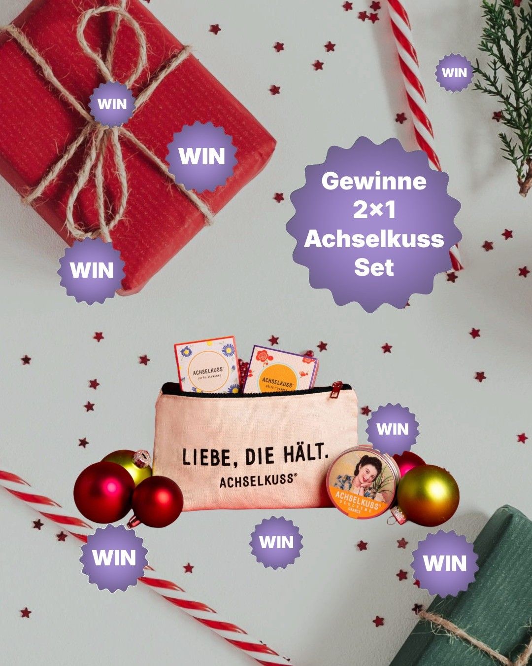 Eine Werbegrafik zeigt eine Geschenktasche mit einem Etikett, auf dem 'Liebe, die halt' steht. Darum herum befinden sich Geschenkanhänger, Ornamente und Sterne. Die Tasche enthält Karten und einen zylindrischen Behälter. Über der Tasche befindet sich ein großes violettes Etikett mit 'Gewinne 2x1 Achselkuss Set'.