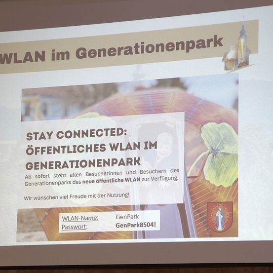 Fotografie von einer Folie, die öffentliches WLAN im Generationenpark ankündigt. Es zeigt den WLAN-Namen und das Passwort. Außerdem werden die Besucher ermutigt, verbunden zu bleiben.
