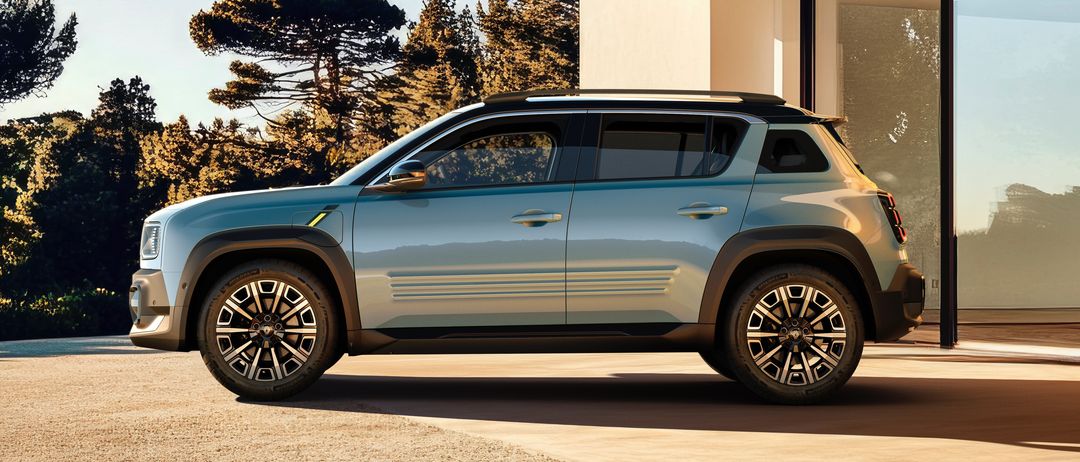 Die Vorderansicht eines blauen SUV, der vor einem modernen Gebäude geparkt ist, mit einem klaren blauen Himmel und einigen Bäumen im Hintergrund.