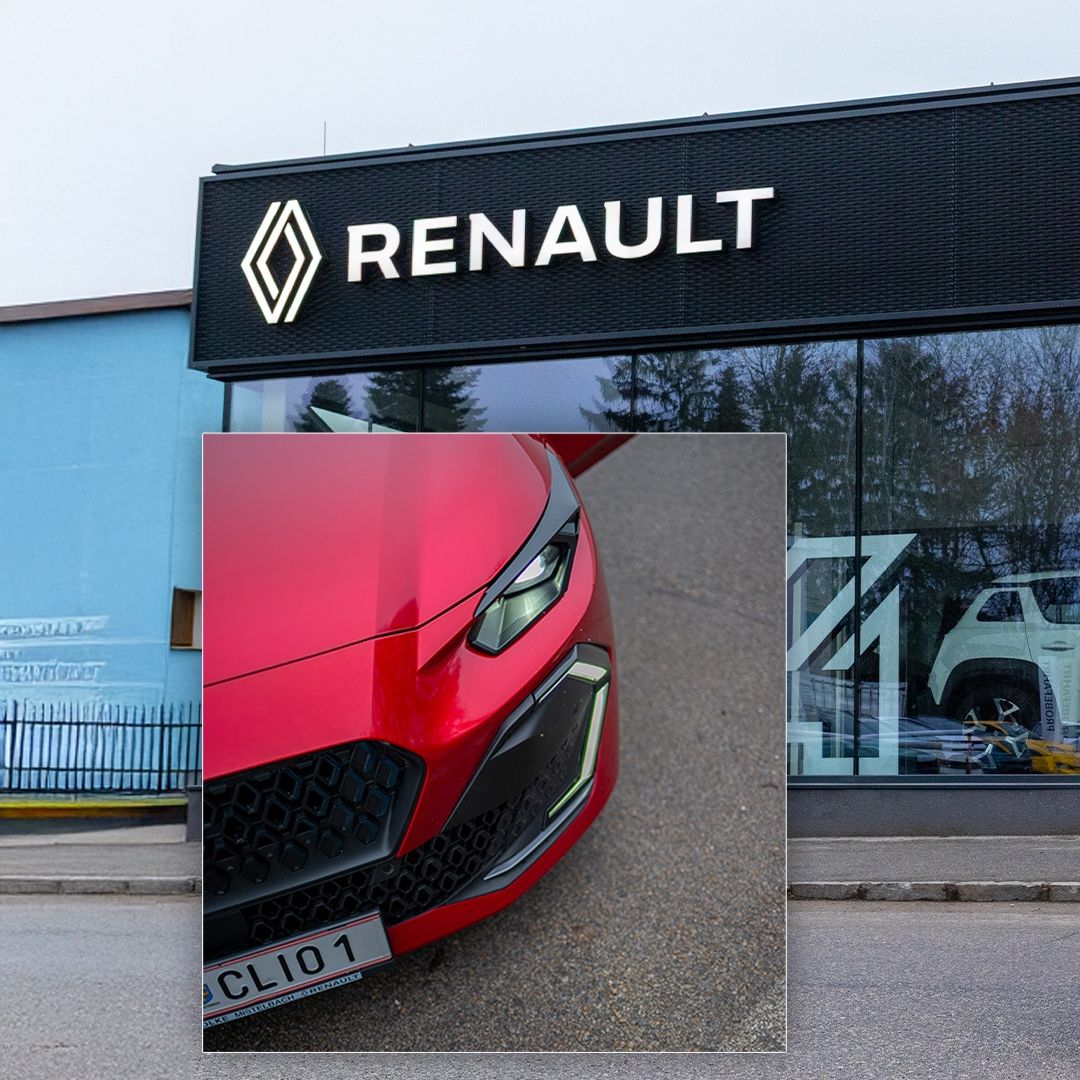 Ein roter Renault Clio vor einem Renault-Händler. Der Händler hat ein modernes Design mit einer schwarzen Wand und Glasfenstern.