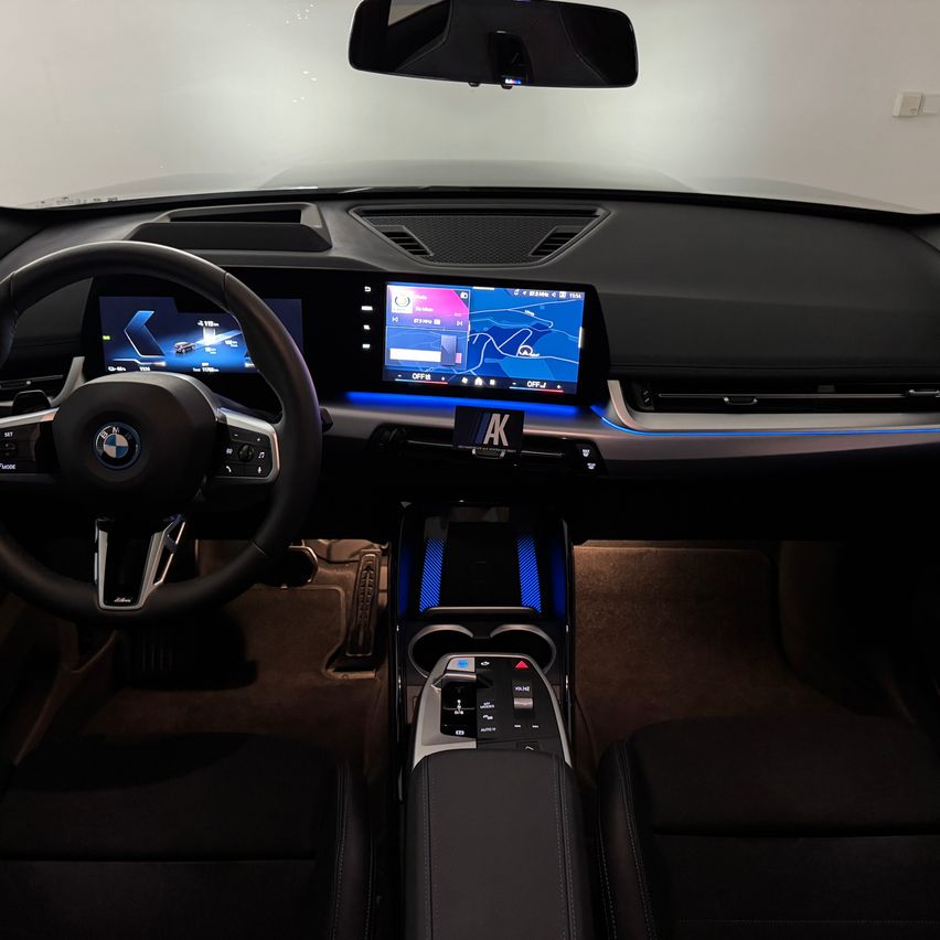 Interior of a BMW car with a dashboard featuring a navigation screen, steering wheel, and control panel.