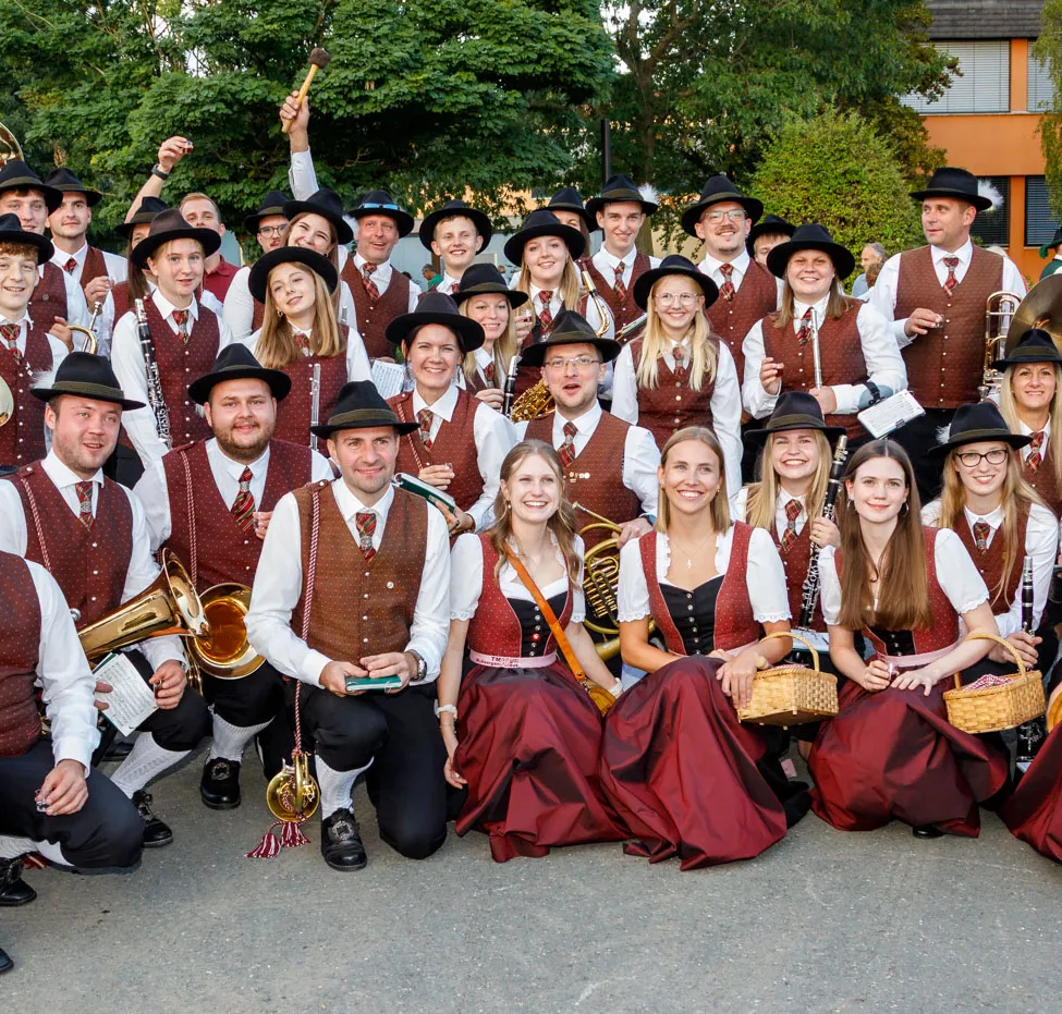 Eine Gruppe von Musikern in traditioneller Kleidung, die mit ihren Instrumenten für ein Foto posiert.