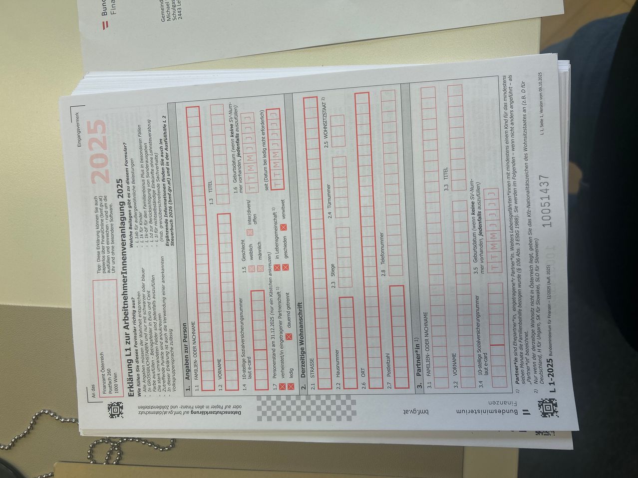 Ein Dokument mit dem Titel 'Erklärung L1 zur Arbeitnehmerveraenderung' für 2025, mit roten Kontrollkästchen, Zahlen und persönlichen Informationen. Das Dokument hat Abschnitte für Familienname, Vorname, Geburtsdatum und andere Details. Es enthält einen QR-Code und ist auf weißem Hintergrund.