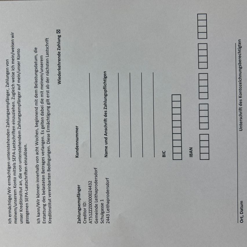 Das Bild zeigt ein Bankdokument mit einem Formular für die Überweisung von Geldern. Es enthält Abschnitte für den Namen des Kunden, Bankdaten und Transaktionsinformationen. Das Formular hat Felder für BIC, IBAN und andere Bankdaten.