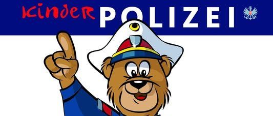 Eine Illustration eines Bären in einer Polizeiuniform, der mit einem Finger über einem blauen Kreis zeigt. Der Text 'POLIZEI' ist oben.