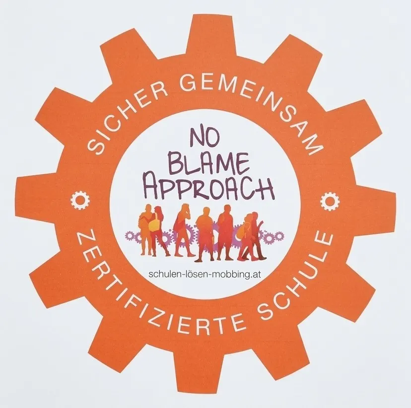 Ein Poster mit einem orangefarbenen Zahnraddesign zeigt den Text 'Sicher Gemeinsam No Blame Approach' und eine Silhouette von Menschen, die gehen.