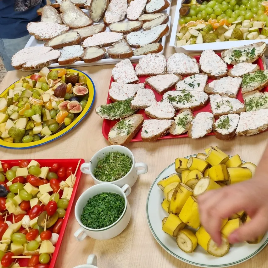 Ein Tisch mit verschiedenen Lebensmitteln, einschließlich Sandwiches, Obst und Gemüse.