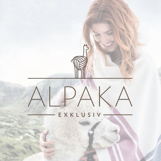 Eine lächelnde Frau mit einem weißen Schal hält ein weißes Alpaka in einer Berggegend. Der Text 'ALPAK' und 'EXKLUSIV' ist über dem Alpaka zu sehen.