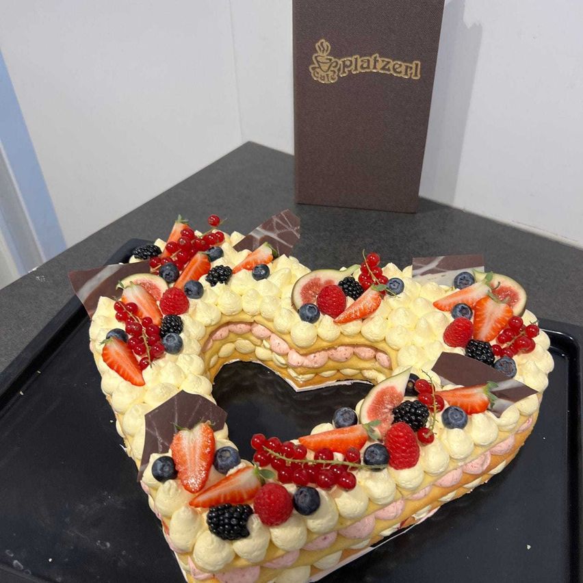 Bild enthält, Symbol, Birthday Cake, Dessert, Food, Text, Food Presentation, Number, Love Heart Symbol, Id Cards, Passport