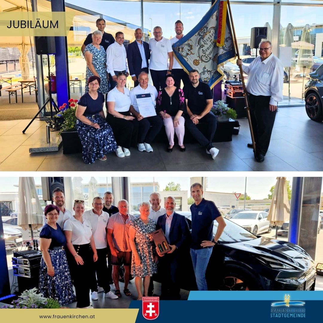 Zwei Gruppen von Menschen in einer Autoausstellung. Eine Gruppe feiert mit einer Flagge und die andere Gruppe steht neben einem schwarzen Auto.