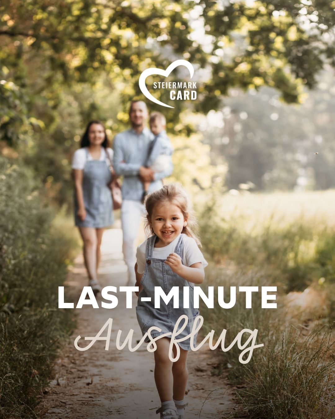 A family walks on a grassy path with a girl running ahead. The father holds a child and the mother follows. The image promotes 'last-minute Ausflug' with the 'Steiermark Card' logo.