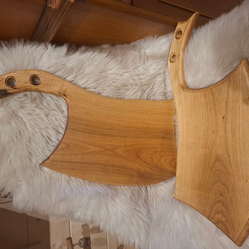 Zwei Holzschnitzmesser mit Griffen auf einem weißen Pelzteppich. Ein Messer hat eine größere Klinge.