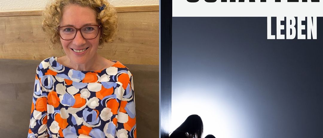 Eine lächelnde Frau in einem gemusterten Hemd sitzt neben einem Buchcover mit dem Titel 'Schatt Le'. Das Cover zeigt eine Silhouette einer sitzenden Person in einem dunklen Raum.