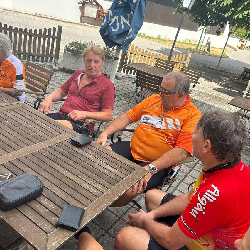 Radfahrer pausieren in einem Gastgarten in Österreich, Männer im Gespräch