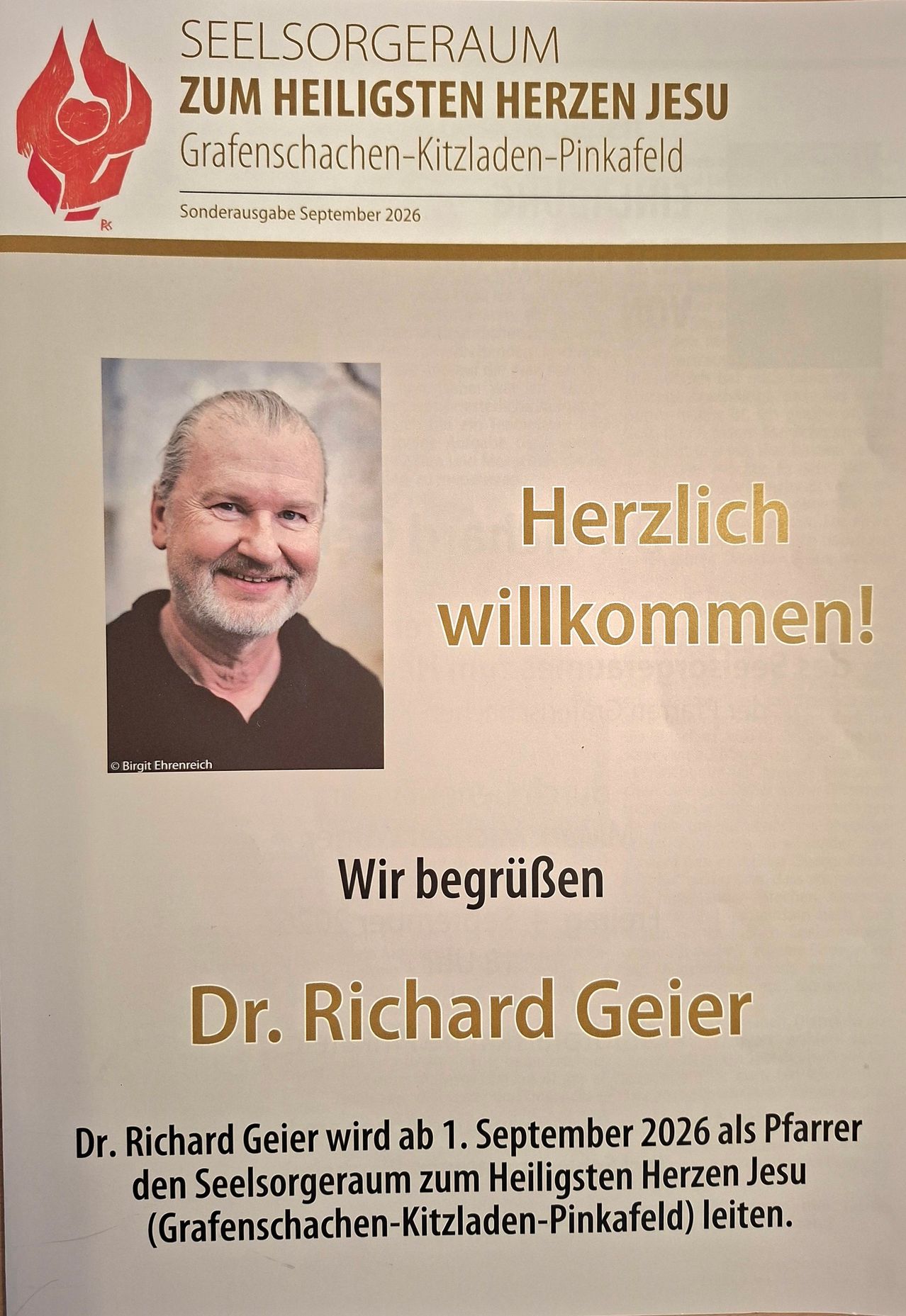 Ein Willkommensposter mit einem lächelnden Mann, Dr. Richard Geiger, einem goldenen Rand und Text auf Deutsch, der 'Herzlich willkommen!' und 'Wir begrüßen Dr. Richard Geiger' lautet. Das Foto ist Birgit Ehrenreich zugeschrieben.