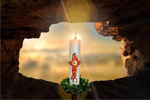 Eine Kerze mit roter Flamme und Buchstaben steht vor einem Höhleneingang, wobei das Licht die Umgebung erhellt.