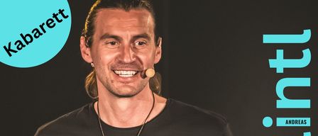 Ein lächelnder Mann mit schwarzem Shirt und Halskette hält ein Buch mit dem Titel 'Auf dem Weg zu mir' in beiden Händen. Der Plakatrand ist blau und der Text ist auf Deutsch.