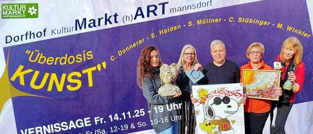 Vier Personen stehen vor einem Plakat für einen Kunstmarkt. Drei halten Kunstwerke, eine ein Snoopy-Zeichnung. Das Plakat hat Text auf Deutsch und Datum und Uhrzeiten für die Veranstaltung.