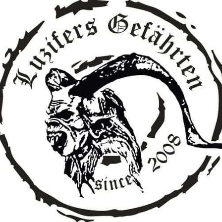 Ein schwarz-weißes Logo mit einem grimmigen Dämonengesicht, umgeben von Stacheldraht, mit den Worten 'Lusters Gefaehrten seit 2008'.