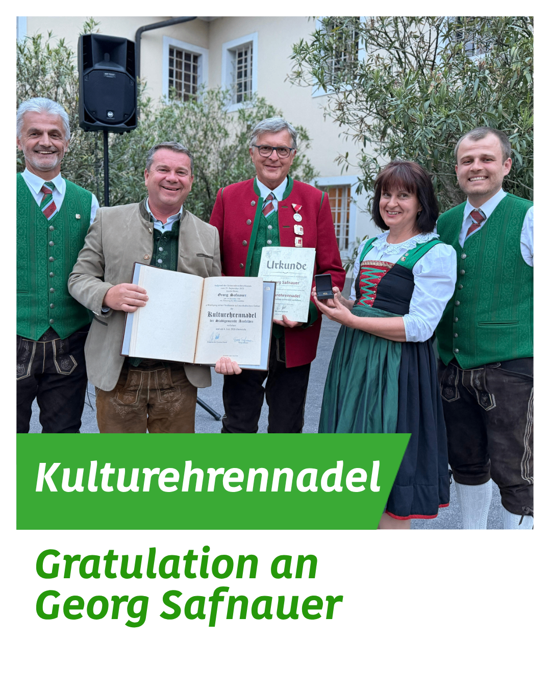 Fünf Menschen stehen lächelnd vor einem Gebäude. Sie halten Urkunden und Auszeichnungen. Ein Mann in der Mitte hält ein Buch. Sie tragen traditionelle Kleidung. Der Text auf dem Bild ist auf Deutsch.