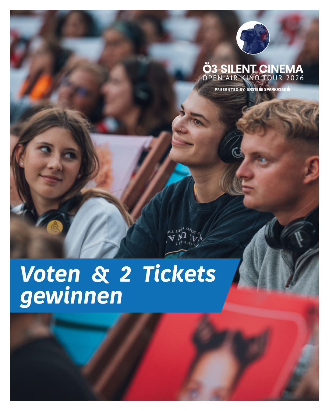 Eine Gruppe von Menschen schaut sich einen Stummfilm an. Sie tragen Kopfhörer und scheinen die Erfahrung zu genießen. Es gibt einen blauen Banner mit Text im Vordergrund.