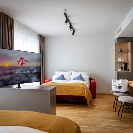 Bild enthält, Interior Design, Floor, Flooring, Home Decor, Screen, Corner, Monitor, Cushion, Furniture, Living Room