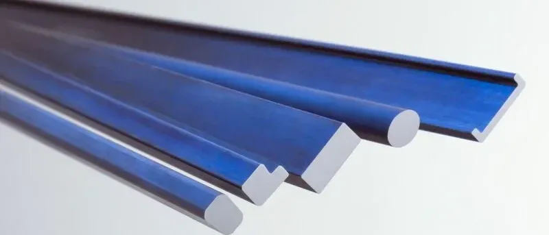 Nahaufnahme von vier blauen rechteckigen Metallstangen mit abgerundeten Kanten auf weißem Hintergrund.