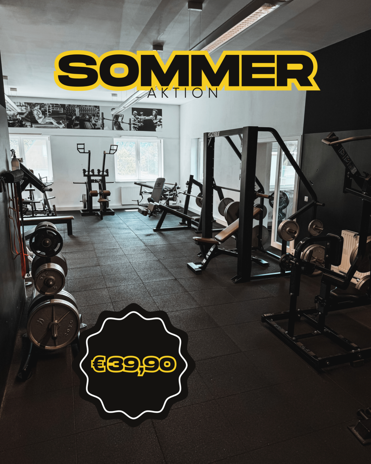 Ein Fitnessstudio mit verschiedenen Trainingsgeräten, darunter eine Langhantel mit Gewichten, eine Langhantelbank und eine Beinpresse. Das Fitnessstudio verfügt über große Fenster und einen Preis von 39,90 Euro.