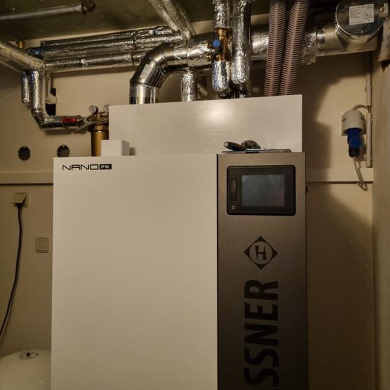 Ein weißer und grauer Apparat mit den Worten Nano und SSNER darauf. Es ist ein Heizgerät mit einem digitalen Display und einem Bedienfeld.