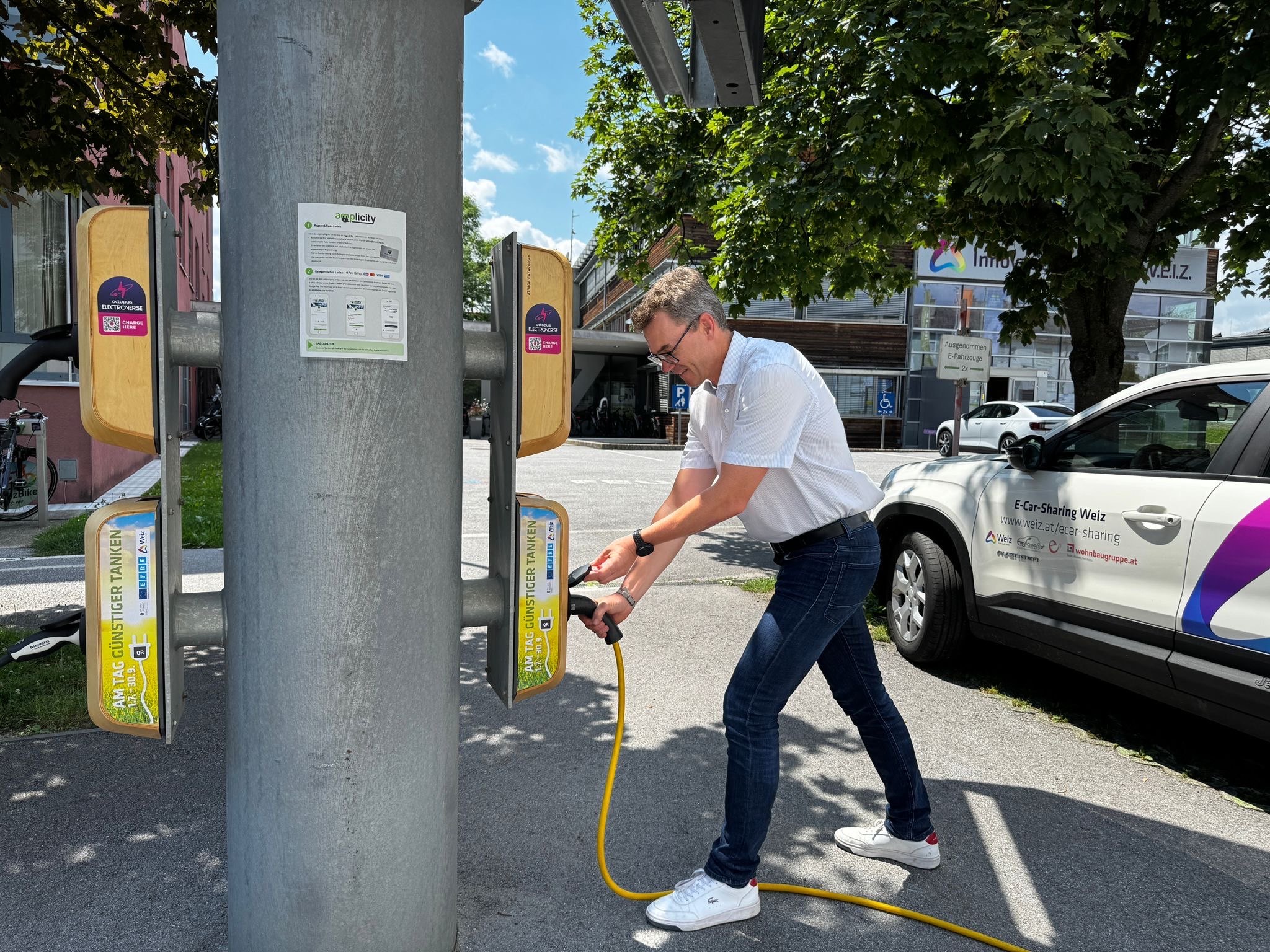 Mann lädt Elektroauto in Weiz