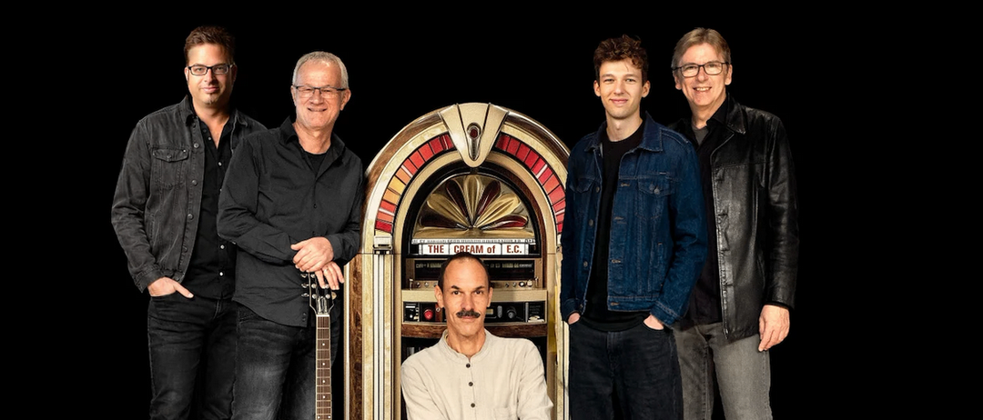 Fünf Männer stehen und knien vor einem alten Jukebox. Ein Mann hält eine Gitarre.