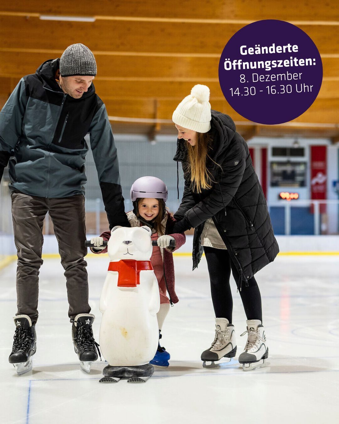 Ein erwachsener Mann und eine Frau eislaufen mit einem kleinen Mädchen, das einen Helm trägt, auf einer Eisbahn. Das Mädchen hält eine weiße Bärenstatue. Sie alle lächeln. Das Bild hat einen Wasserzeichen in der oberen rechten Ecke.