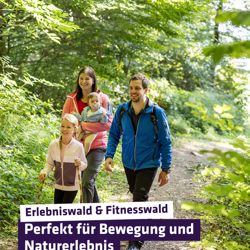 Eine Familie wandert im Wald. Eine Frau trägt ein Baby und lächelt, während sie mit einem Mann geht. Beide halten Wanderstöcke. Der Text lautet 'Erlebniswald & Fitnesswald, Perfekt für Bewegung und Naturerlebnis.'