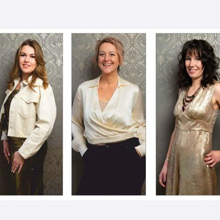 Drei Frauen stehen vor einer Tapete mit komplizierten Mustern. Die Frau auf der linken Seite trägt eine weiße Jacke und grüne Hose, die in der Mitte ein weißes Oberteil und schwarze Hose, und die auf der rechten Seite ein goldenes Kleid.