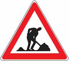 A warning sign shows a silhouette of a person digging with a red border. It warns of potential hazards or construction ahead.