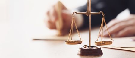 Ein Anwalt versiegelt ein Dokument mit einem Stempel auf einem Holztisch, was Gerechtigkeit und Recht symbolisiert.