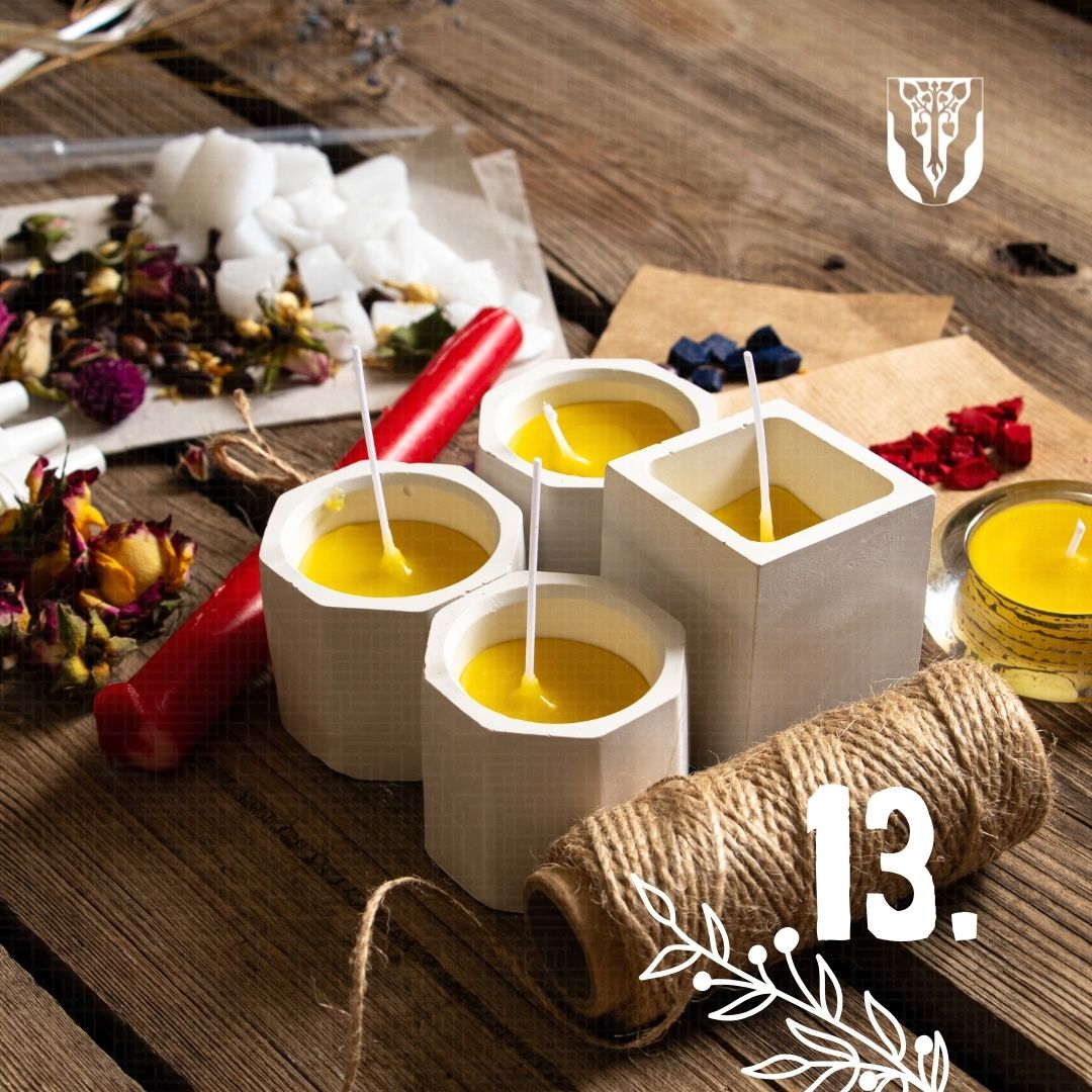 Vier weiße sechseckige Kerzen mit gelbem Wachs und Stäben stehen auf einer Holzoberfläche. Es gibt auch einige getrocknete Blumen, ein rotes Objekt und eine Rolle Schnur.