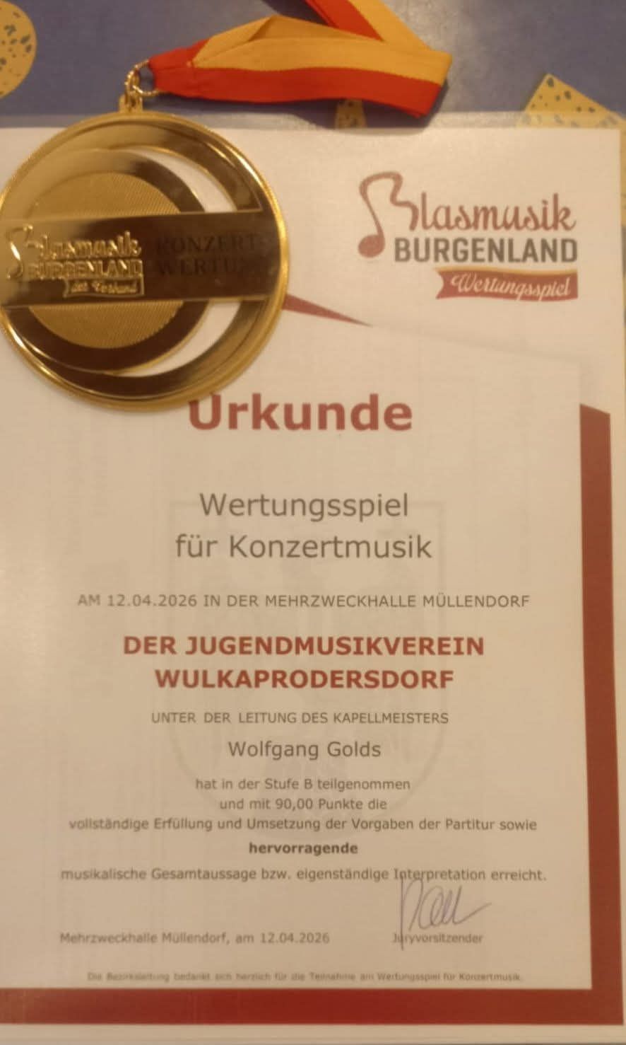 A golden medal for concert music. The Youth Music Association of Wulkau-Prodersdorf received the certificate on April 12, 2026, at the Mehrzweckhalle in Mullendorf. Under the direction of the choirmaster Wolfgang Golds.