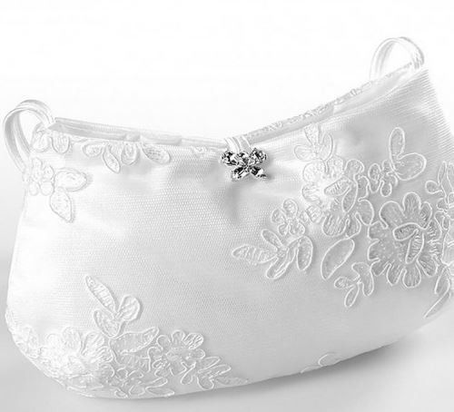 Eine weiße Handtasche mit Blumenstickerei und einem silbernen Kristall in der Mitte. Die Tasche hat oben einen Henkel.